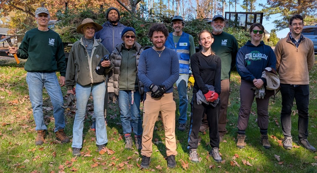 Team members posing in front of trailer load of privet